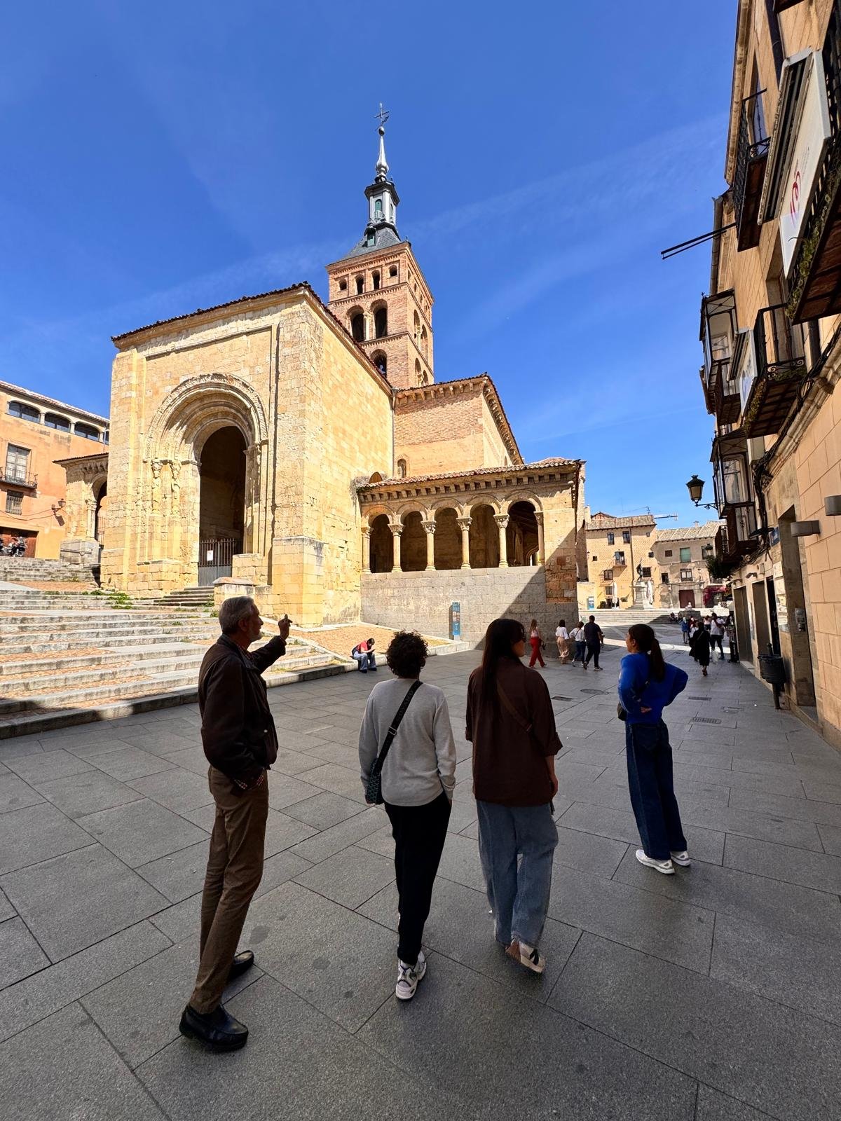 Host explaining the history to a private group tour in front of a medieval church